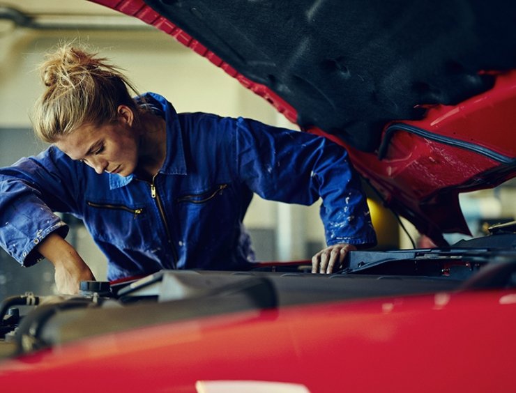 Donna meccanico al lavoro nel vano motore