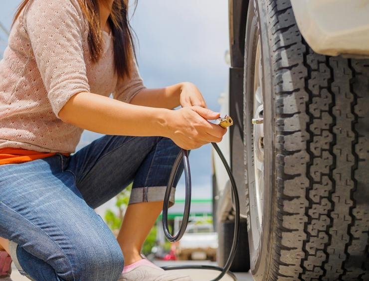 une femme travaille sur un pneu